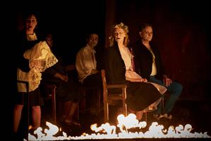 Une femme assise sur une chaise qui regade du feu