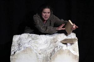 Une femme derrière un rocher