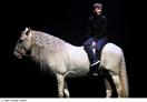 Alex Lutz en amazone sur un cheval blanc