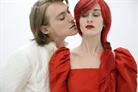 Un homme en blanc embrasse une femme en rouge