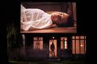 Sur un écran géant au-dessus d'une maison, une femme couchée